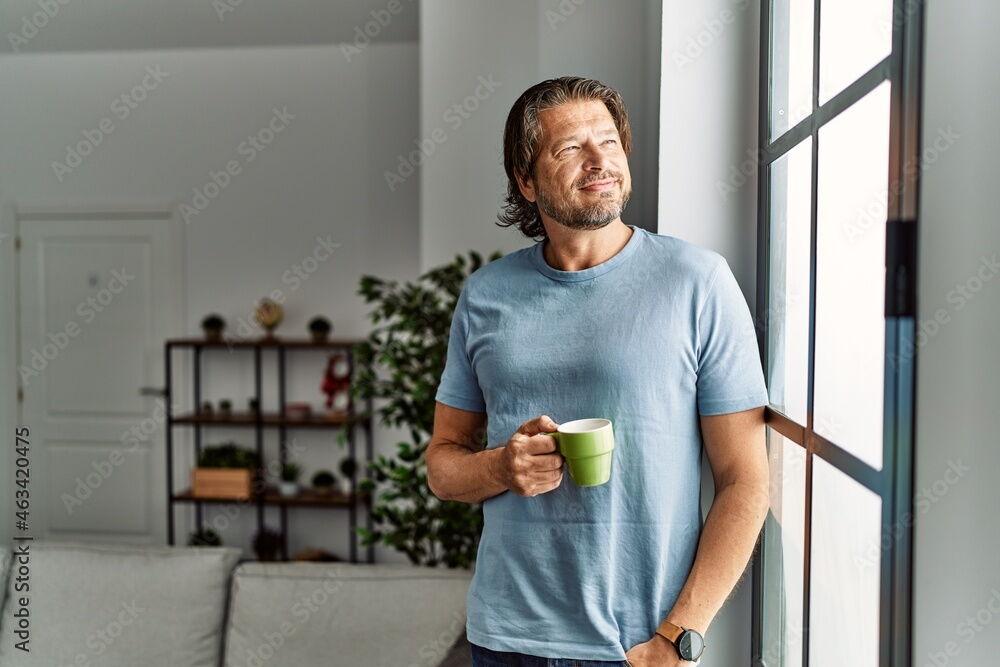 Mann in hellem Wohnraum am Fenster